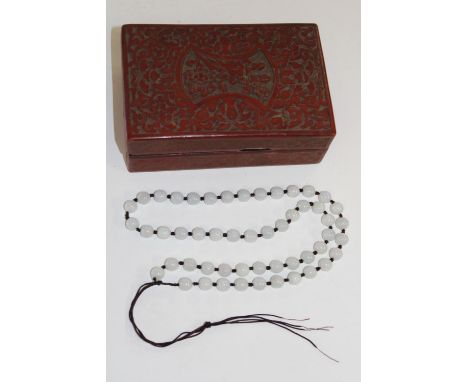 A Chinese cinnabar box with a jade necklace 