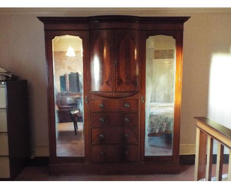 A good quality mahogany triple wardrobe with twin mirrored doors measuring approximately 212 cm x 197 cm x 56 cm.

The item i