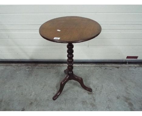 A circular topped side table with bobbin turned column, approximately 68 cm x 43 cm.