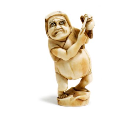 NETSUKE.Japan, Meiji-Zeit, H 5,3 cm.Elfenbein, geschnitzt in Form von Daruma, die Schellen anschlagend. Signiert.Provenienz: 