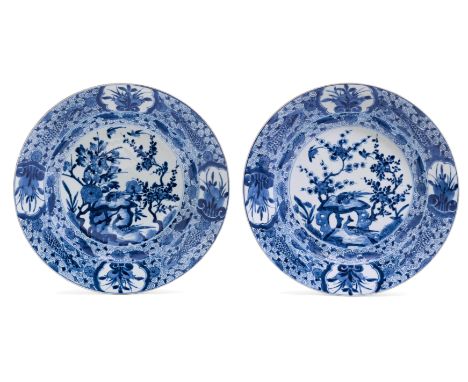 PAAR GROSSE RUNDPLATTEN.China, Kangxi-Periode, Ø 38 cm.Unterglasurblauer Dekor von Vögeln und Blumen in einem Garten. Die Fah