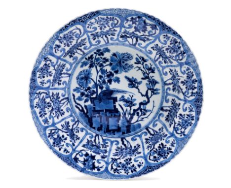GROSSER WANDTELLER.China, Kangxi-Periode, Ø 34,5 cm.Unterglasurblauer Dekor von Päonien und Magnolien sowie einem Vogel auf e