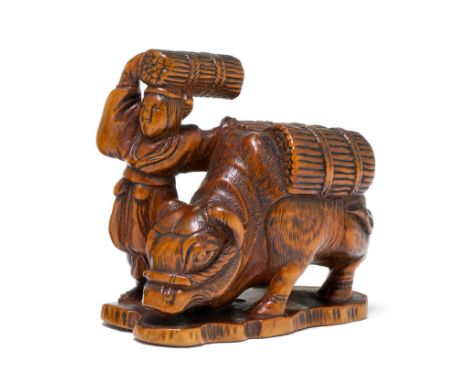 NETSUKE.Japan, Meiji-Zeit, H 4,3 cm.Buchsbaumholz, geschnitzt als Oharame. Ein Holzbündel auf dem Kopf tragend, marschiert di