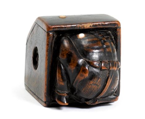 NETSUKE.Japan, Meiji-Zeit, H 2,6 cm.Buchsbaumholz und Beineinlagen, geschnitzt als Oni, der sich vor Bohnenbewurf in einem Ko