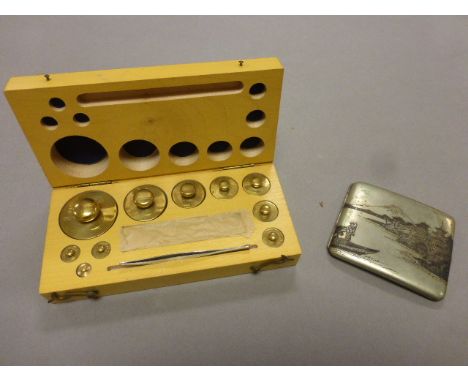A white metal cigarette case, stamped "sterling" along with a cased set of weights 