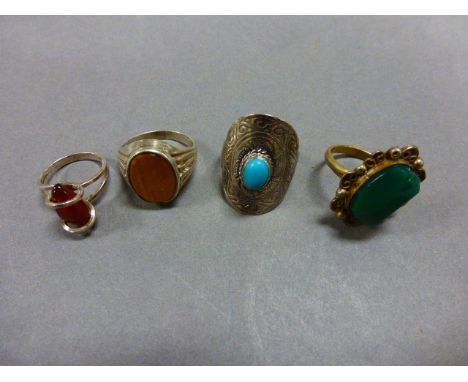 Three silver and one white metal ring, with various stones including turquoise and tiger's eye (4)