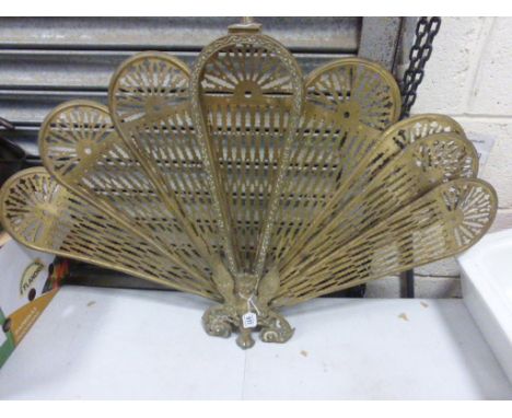 A brass fan fire screen