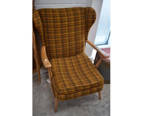 A vintage Ercol or similar wing back armchair with moquette upholstery