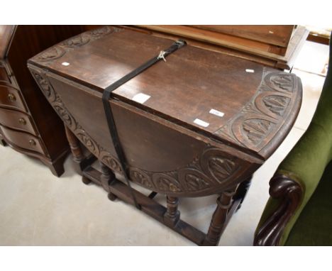 A late 19th or early 20th Century gate leg dining table having lunette carved decoration