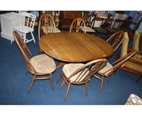 An Ercol table and set of six Ercol hoop back chairs