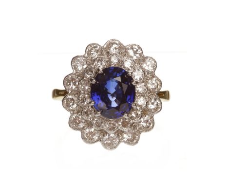 SAPPHIRE AND DIAMOND CLUSTER RINGset with a central oval faceted sapphire of approximately 2.50 carats within a double diamon