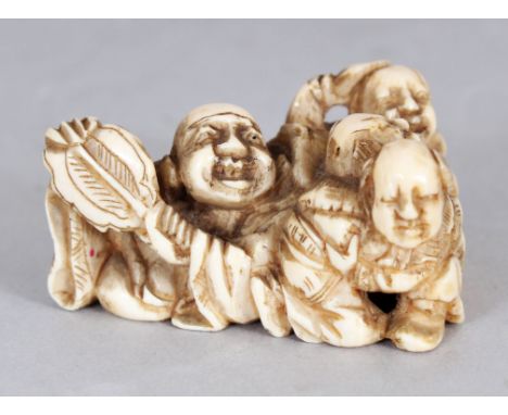 A JAPANESE MEIJI PERIOD TRIANGULAR SECTION IVORY NETSUKE, pierced and carved in the form of Hotei in the company of three sma