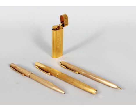 A CARTIER GILT LIGHTER, No. 97799, two Parker pens and a Waterman pen (4).