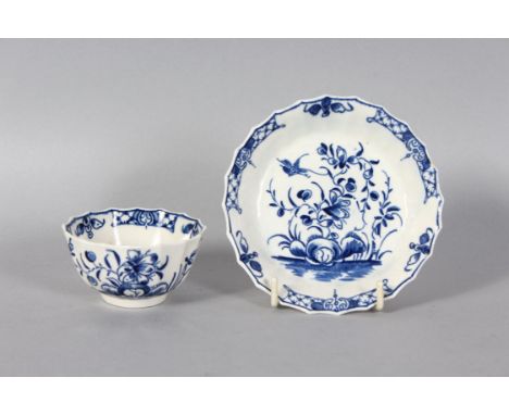 A GOOD 18TH CENTURY WORCESTER TEA BOWL AND SAUCER, painted and moulded with flowers in blue and white.
