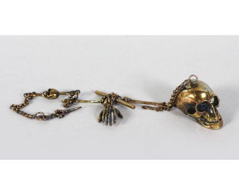 A BRASS SKULL SHAPE SNUFF BOX AND CHAIN. 1.5ins long.