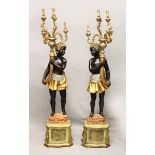 A PAIR OF BLACKAMOOR FIGURES, each holding a horn sconce, and set in a rock and giltwood base,