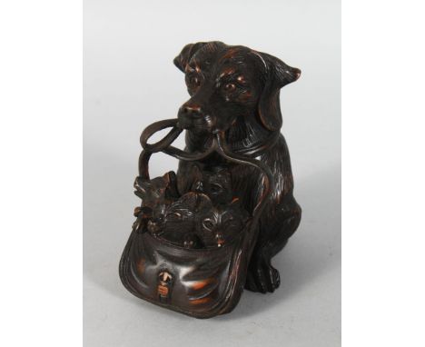 AN AMUSING CARVED WOOD INKWELL, modelled as a dog holding a bag of puppies in it's mouth. 5ins high.