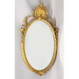 A 19TH CENTURY OVAL GILT FRAMED MIRROR, with shell cresting and harebell swags. 2ft 7ins high x