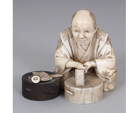 A SIGNED JAPANESE MEIJI PERIOD SECTIONAL IVORY & WOOD OKIMONO OF A SEATED ARTISAN, holding a chisel, his pipe and pouch besid