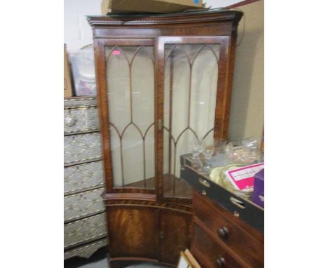 A reproduction mahogany corner cabinet having dental moulded cornice and bracket feet 74" H x 36"W 