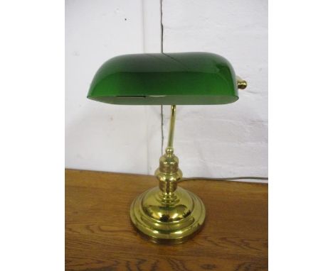 A modern brass desk lamp with a green glass shade 