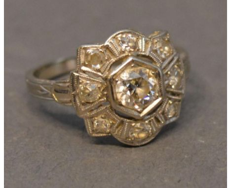 A 14 Carat White Gold Diamond Cluster ring set with a central diamond surrounded by diamonds 