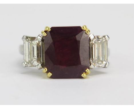 A Ruby and Diamond Three Stone Ring in a precious white and yellow metal setting, 10.45x8.95mm principal stone flanked by 5.8