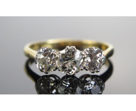 An 18ct Gold and Old Cut Diamond Three Stone Ring, c. 6.05mm principal platinum set stone flanked by c. 5.3mm stones, stamped