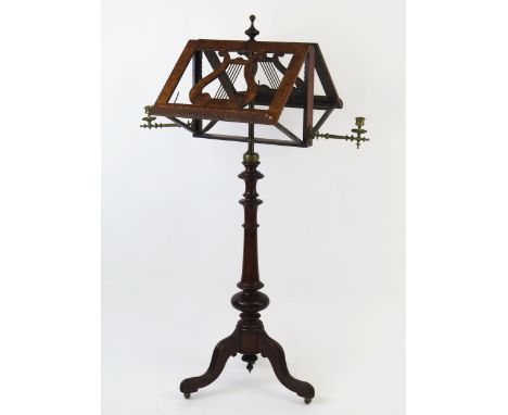 A Victorian walnut duet music stand, with hinged lyre-shaped stands, and hinged brass candlesticks, mounted on a ring turned 