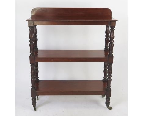 A 19th century mahogany three tier dumb waiter, of rectangular outline, raised on ring turned supports, terminating in caster
