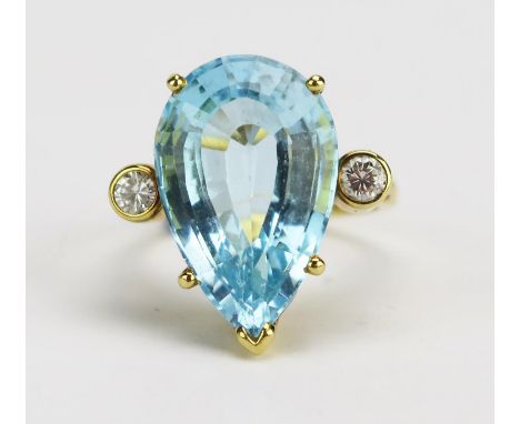 An 18ct Gold Blue Topaz and Diamond Ring, c. 19.1x12.1mm principal pear cut with 2.4mm brilliant round cut rub over set stone