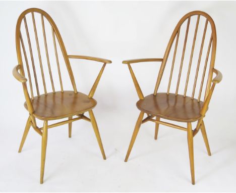 A pair of Ercol Quaker elbow chair with arched backs, solid seats on turned legs. 