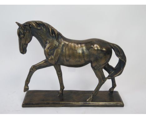 A bronzed resin model of a stallion, on a rectangular plinth base, 41cm long, 34cm high. 