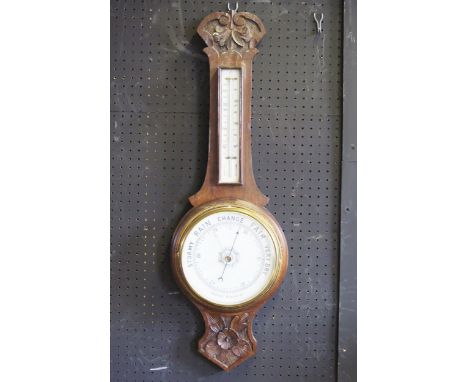 An Edwardian oak cased wheel barometer, or arched outline,  with mercurial thermometer, and aneroid barometer with 20cm ivori