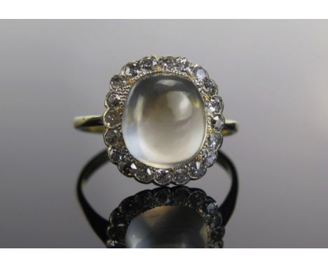An 18ct Gold, Moonstone and Old Cut Diamond Cluster Ring, 11.6x10mm principal stone, 16.2x15.3mm head, size T.75, hallmarked,