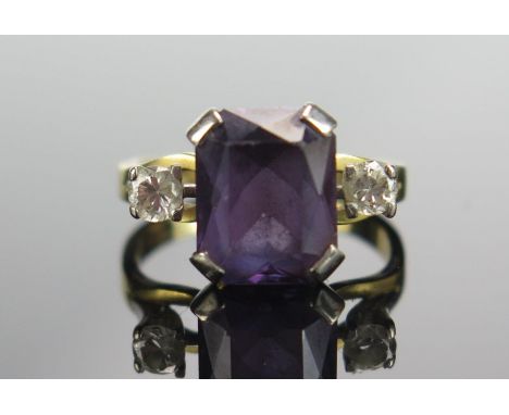 An 18ct Gold, Amethyst and Diamond Three Stone Ring, 10.4x8.3mm principal stone with brilliant round cuts, size K.75, stamped