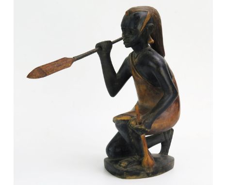 An African Carved Wooden Model of a hunter with spear, signed John Ngony, 32cm tall 