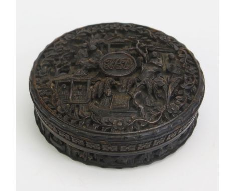 A 19th century Chinese carved tortoiseshell snuff box of circular form, with all over decoration of figures in a landscape se