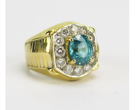 A Topaz and Diamond Ring in a precious yellow metal setting, 7.7x6.3mm principal stone, surrounded by 12 c. 1.9mm brilliant r