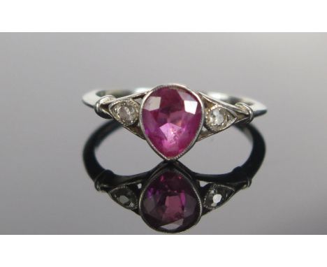 A Ruby and Old Cut Diamond Three Stone Ring in a precious white metal millegrain setting, c. 6.3x5.4mm pear shaped principal 