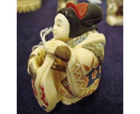 A Japanese carved ivory Okimono as a seated robed female playing a lute, 6cm high 