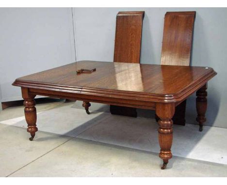 An impressive Edwardian wind out dining table, rectangular deep moulded edge top, plain frieze, two extra leaves, supported o