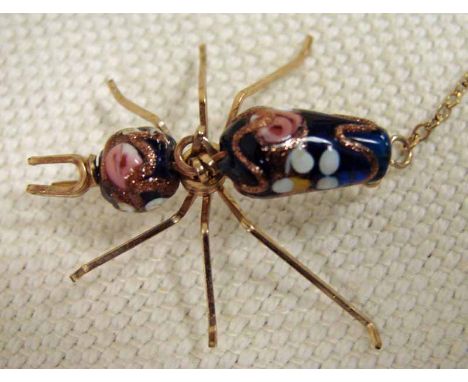 An antique fashion brooch modelled as an ant, gilt wirework construction with enamel and gilt decorated blue glass head and b