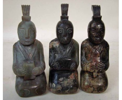 A set of three Chinese jade Funerary figures, as keeling attendants holding gifts, ranging in colour from mottled green to ru