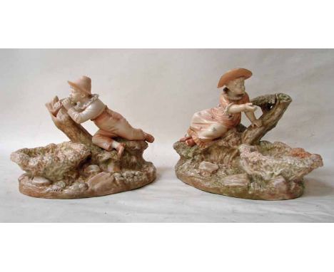 A pair of Royal Worcester blush ivory figural groups, modelled by James Hadley as a Boy and Girl lying on a tree trunk, the b