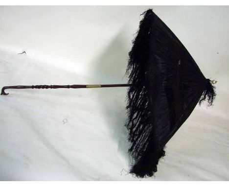 A late 19th century ladies small parasol, dark brown silk with loose tassels, folding carved wooden handle, one stick broken,