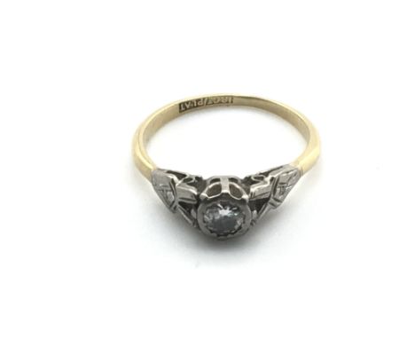 An 18ct gold and platinum ring set with a small diamond. 2.3g and size N 1/2