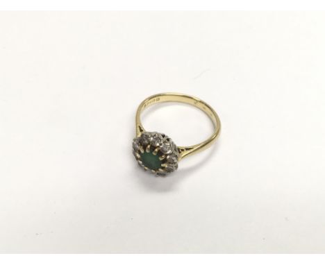 An 18ct gold ring set with diamonds and a green central stone. Approx weight 3.73 grams, size M1/2.