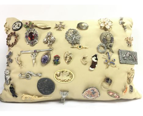 A cushion of vintage brooches. Postage category C