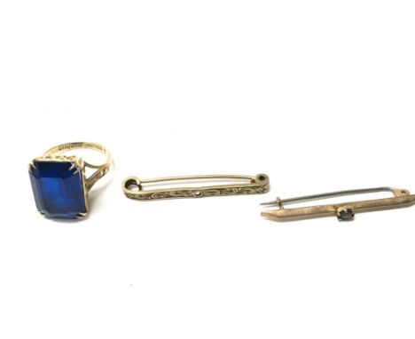 A 9ct gold ring set with blue stone and two 9ct gold brooches. 7.97g total. Postage B